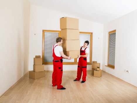 Local movers unloading boxes and furniture at a new home