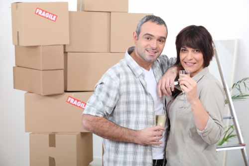 Packed moving boxes and furniture prepared for transport in Acton